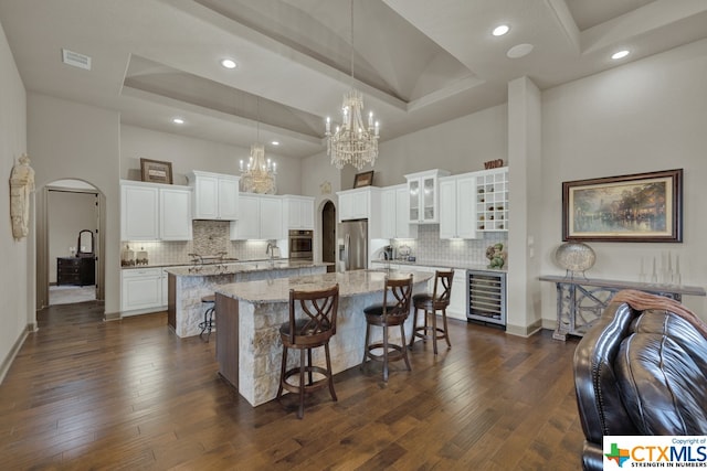 kitchen with dark wood-type flooring, a kitchen island, appliances with stainless steel finishes, and decorative backsplash