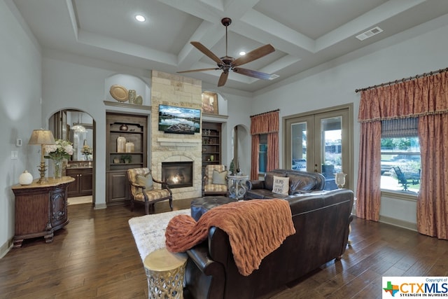 living room with dark wood-type flooring, coffered ceiling, ceiling fan, and a fireplace