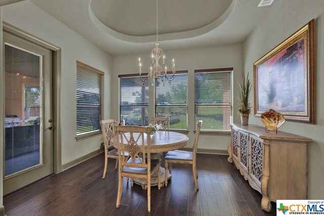 505 Cantera Rdg, New Braunfels, TX 78132 - dining area with a chandelier, dark wood-style flooring, baseboards, and a tray ceiling
