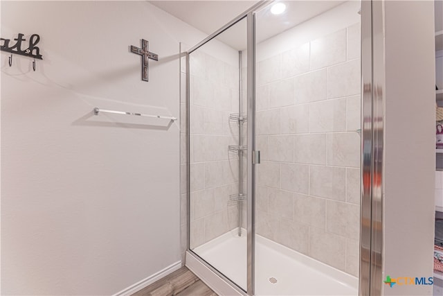 bathroom featuring hardwood / wood-style flooring and a shower with door