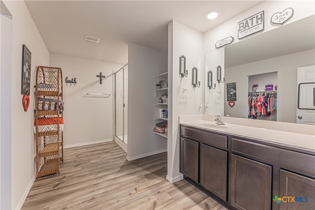 bathroom featuring an enclosed shower, vanity, and hardwood / wood-style flooring