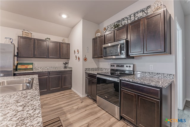 kitchen featuring stainless steel appliances, dark brown cabinetry, sink, light hardwood / wood-style floors, and lofted ceiling