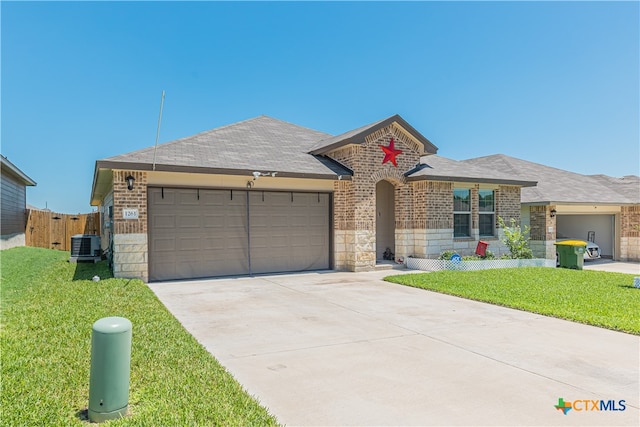 ranch-style home featuring central AC unit, a garage, and a front lawn