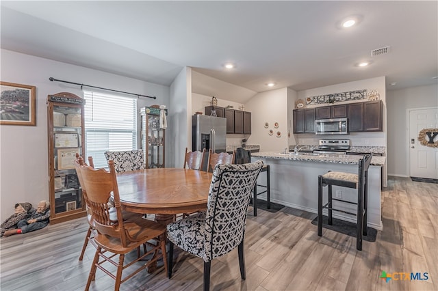 dining area featuring sink and light hardwood / wood-style flooring