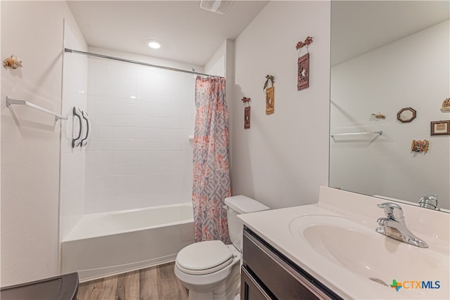 full bathroom with hardwood / wood-style flooring, vanity, toilet, and shower / tub combo