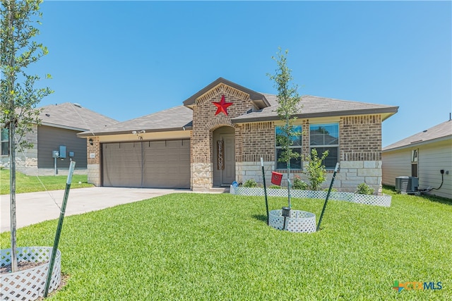 ranch-style house featuring a front lawn, a garage, and central AC unit