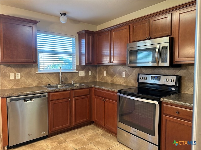 kitchen featuring decorative backsplash, stainless steel appliances, sink, and light tile patterned floors