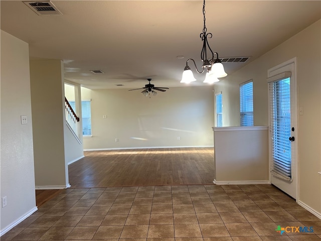 interior space with ceiling fan with notable chandelier and dark hardwood / wood-style flooring