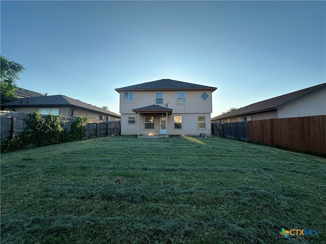 back of house featuring a lawn