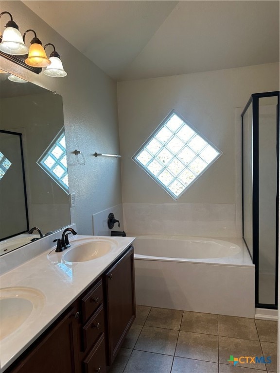 bathroom featuring vanity, a healthy amount of sunlight, tile patterned floors, and a bathtub