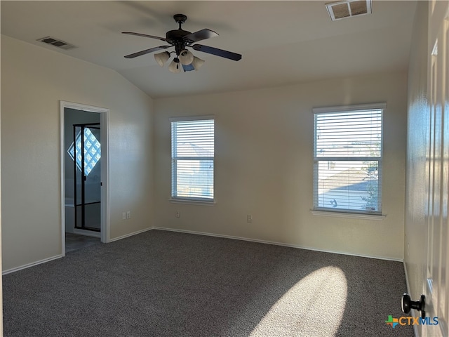 carpeted spare room with a healthy amount of sunlight, ceiling fan, and vaulted ceiling