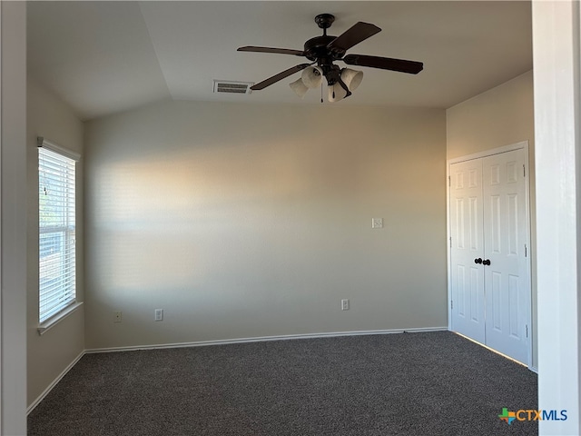 unfurnished room featuring ceiling fan, dark colored carpet, and lofted ceiling