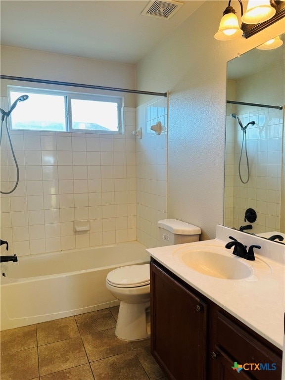 full bathroom with vanity, tile patterned floors, toilet, and tiled shower / bath combo