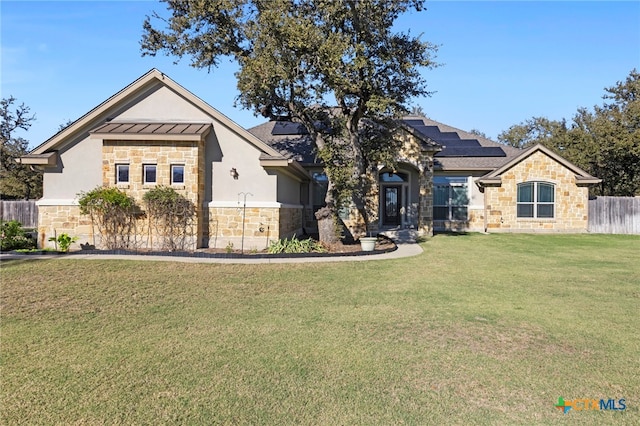 view of front of house featuring a front yard and solar panels