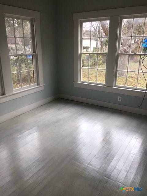 spare room featuring wood finished floors and baseboards