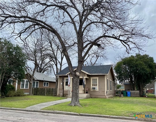 bungalow-style house featuring fence and a front yard