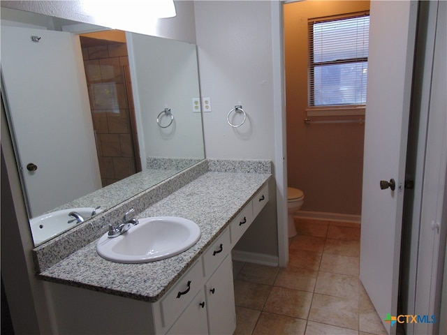 bathroom featuring tile patterned flooring, vanity, and toilet