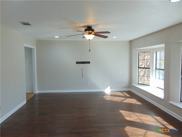 spare room with dark hardwood / wood-style floors and ceiling fan