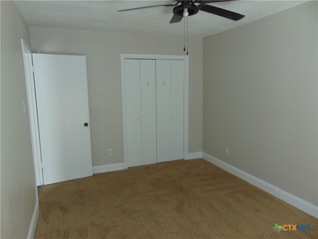 unfurnished bedroom with carpet flooring, a closet, and ceiling fan