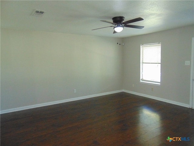 empty room with dark hardwood / wood-style flooring and ceiling fan