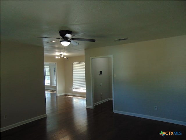 unfurnished room with ceiling fan and dark wood-type flooring