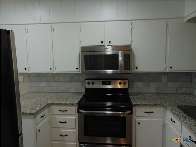 kitchen with white cabinetry, stainless steel appliances, and light stone counters