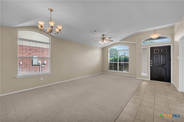 entryway featuring ceiling fan with notable chandelier, light tile patterned floors, and lofted ceiling