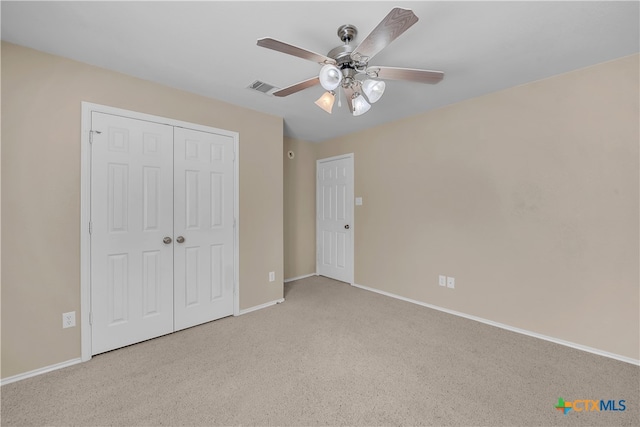 unfurnished bedroom featuring a closet, light carpet, and ceiling fan