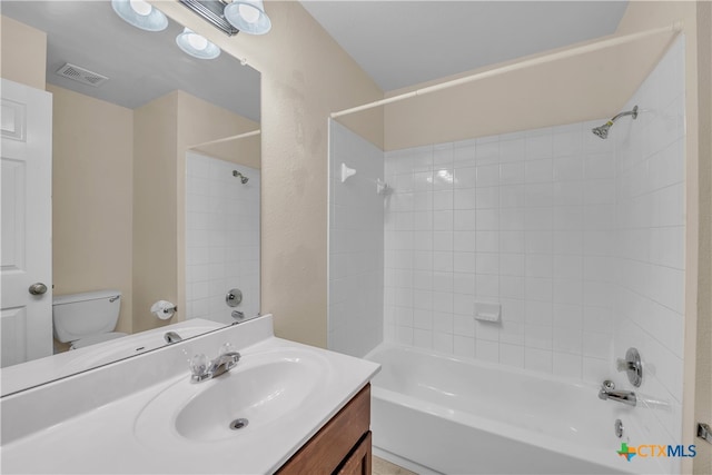 full bathroom with vanity, tiled shower / bath, and toilet