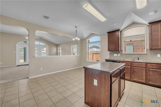 kitchen with a wealth of natural light, sink, lofted ceiling, and a kitchen island