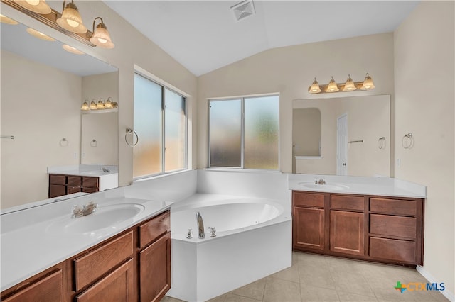 bathroom with a bath, vanity, tile patterned floors, and lofted ceiling