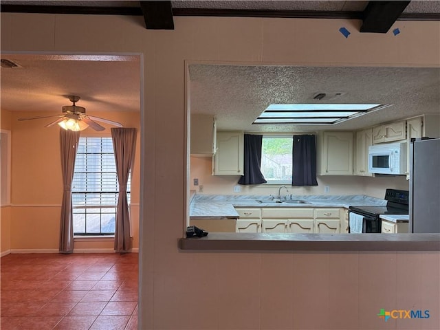 kitchen featuring a textured ceiling, a sink, visible vents, black electric range, and white microwave