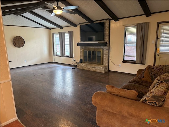 unfurnished living room featuring lofted ceiling with beams, wood finished floors, ceiling fan, and a brick fireplace