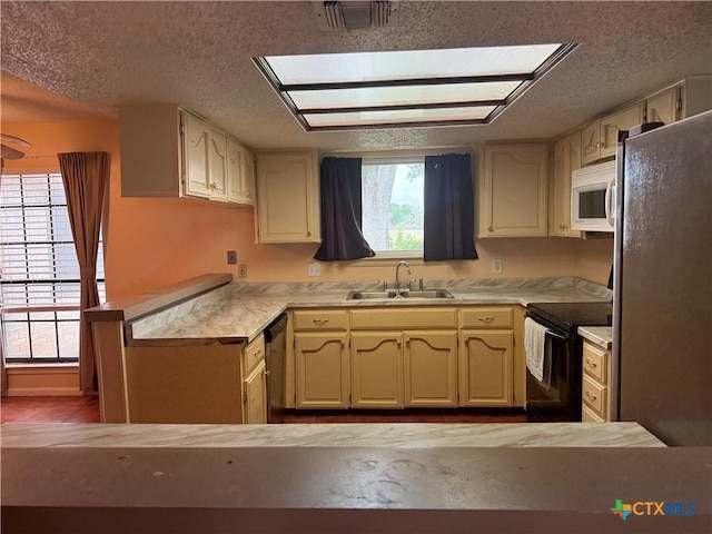 kitchen featuring a textured ceiling, visible vents, a peninsula, stainless steel appliances, and a sink