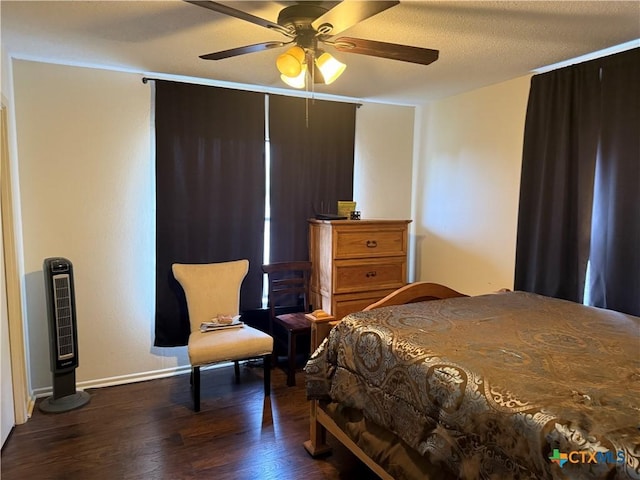 bedroom featuring dark wood finished floors, baseboards, ceiling fan, and a textured ceiling