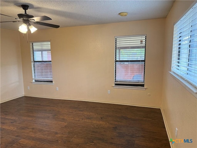 unfurnished room featuring baseboards, a ceiling fan, wood finished floors, and a textured ceiling