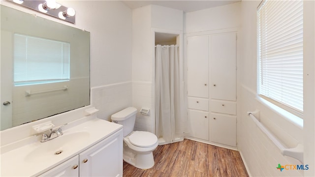 bathroom featuring hardwood / wood-style flooring, vanity, toilet, and tile walls