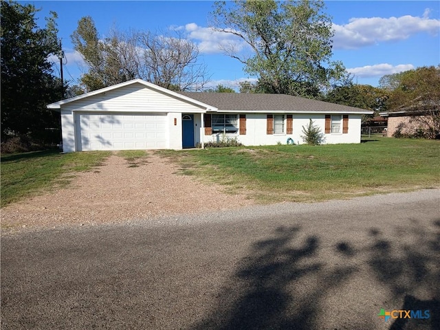 ranch-style house featuring a garage and a front lawn