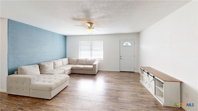 living room with ceiling fan, hardwood / wood-style floors, and a textured ceiling