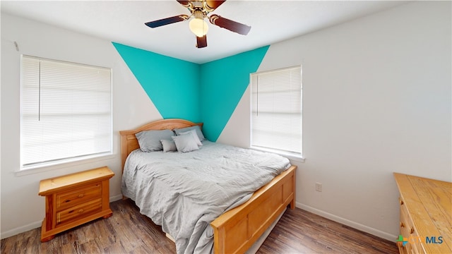 bedroom with dark hardwood / wood-style floors and ceiling fan