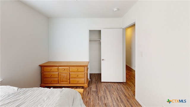 bedroom featuring dark hardwood / wood-style floors and a closet