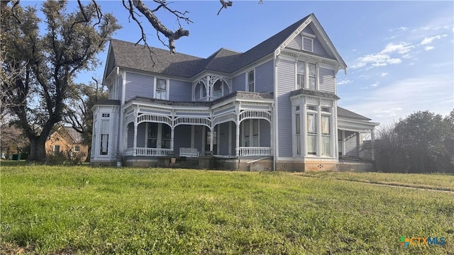 victorian house with a front lawn and a porch