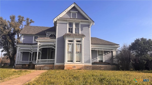 victorian home with covered porch and a front lawn