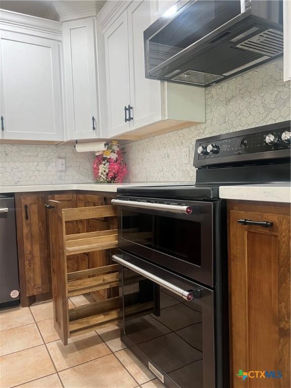 1102 Crockett, Cotulla, TX 78014 - kitchen featuring double oven range, white cabinets, light countertops, ventilation hood, and dishwashing machine