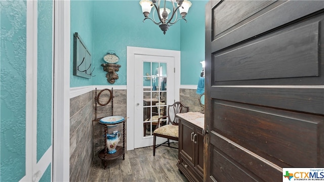 interior space with an inviting chandelier, tile walls, and hardwood / wood-style floors