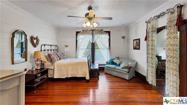 bedroom featuring wood walls, dark wood-type flooring, ceiling fan, and wooden ceiling