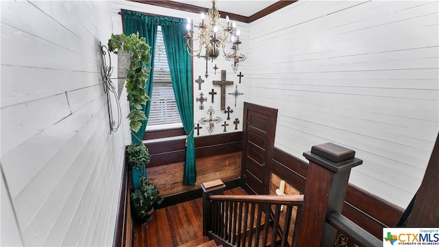 interior space with hardwood / wood-style flooring, wood walls, and a chandelier