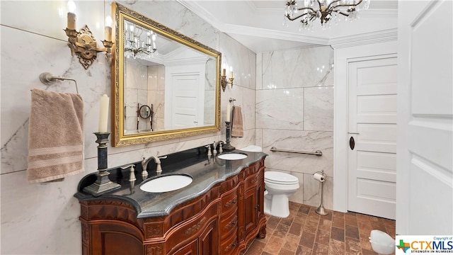 bathroom with a chandelier, vanity, crown molding, toilet, and tile walls