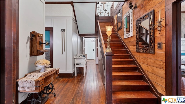 stairway with wood walls and hardwood / wood-style floors