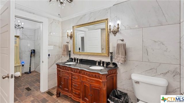 bathroom with crown molding, toilet, and tile walls